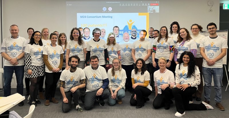 Group picture of the RE-SAMPLE Consortium from March 2023. Participants are wearing t-shirts with project logo and number 100 to mark the enrollment of the 100th patient in the project.