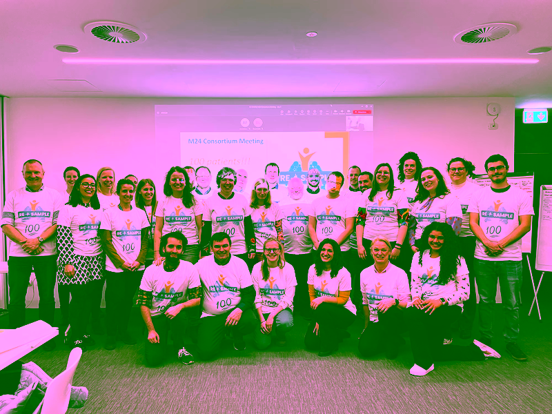 Group picture of the RE-SAMPLE Consortium from March 2023. Participants are wearing t-shirts with project logo and number 100 to mark the enrollment of the 100th patient in the project.