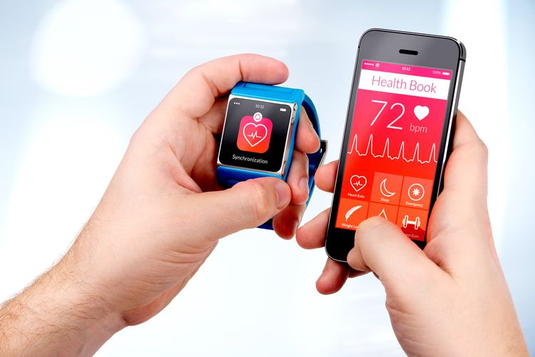 Hands holding a mobile phone with a health application and a fitness tracker